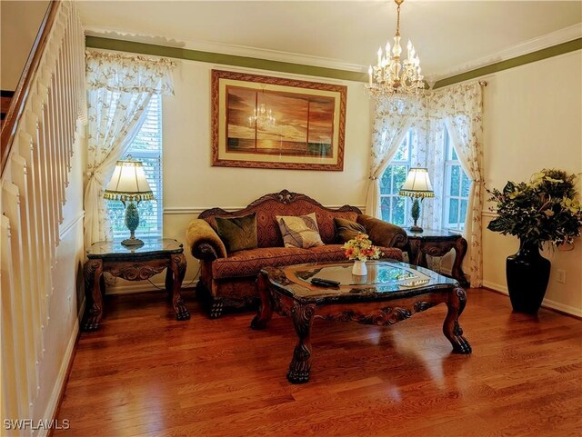 living area featuring a chandelier, hardwood / wood-style floors, and ornamental molding