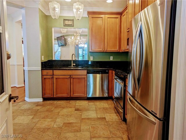 kitchen with appliances with stainless steel finishes, dark stone counters, sink, decorative light fixtures, and an inviting chandelier