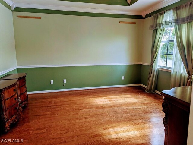 unfurnished room featuring ornamental molding and hardwood / wood-style flooring