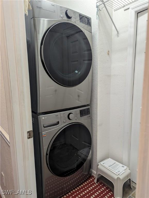 laundry area featuring stacked washer / drying machine