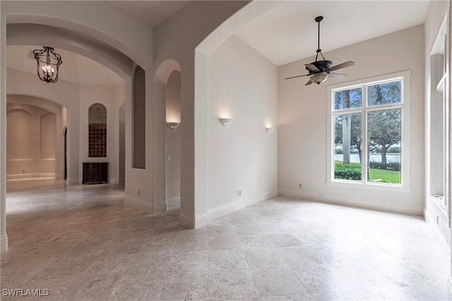 empty room featuring ceiling fan with notable chandelier