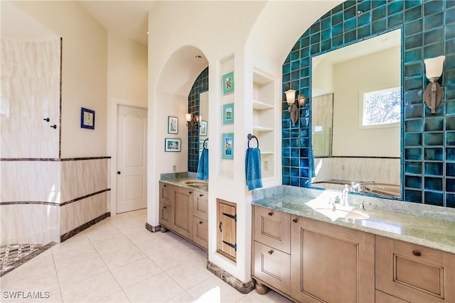 bathroom with tile patterned flooring, vanity, tile walls, and built in shelves