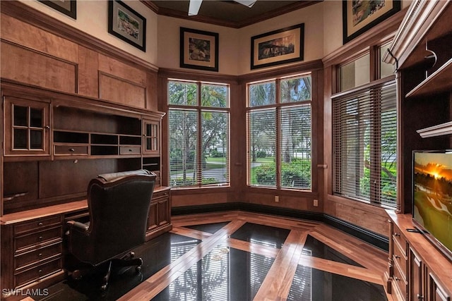 home office with built in desk and crown molding