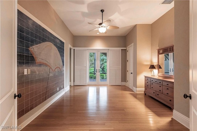 interior space with ceiling fan, french doors, and wood-type flooring