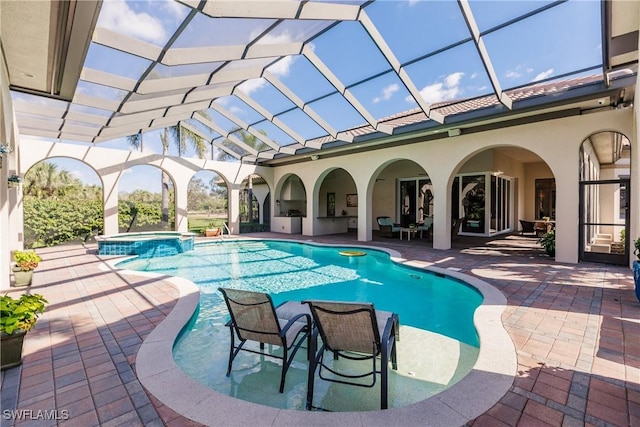 view of swimming pool featuring an in ground hot tub, a patio area, and a lanai