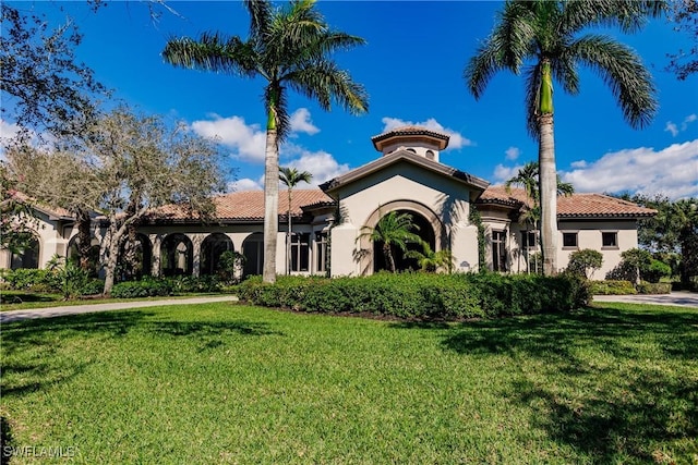 mediterranean / spanish house with a front yard