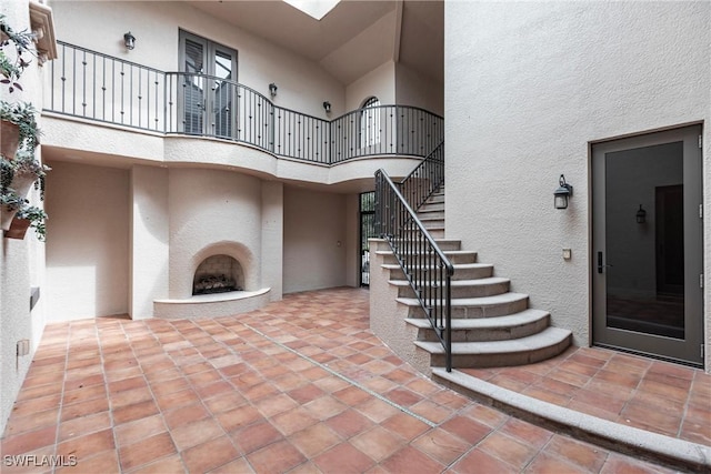 interior space with a towering ceiling and an outdoor fireplace