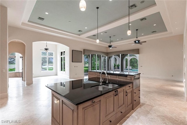 kitchen featuring a wealth of natural light, sink, an island with sink, and decorative light fixtures