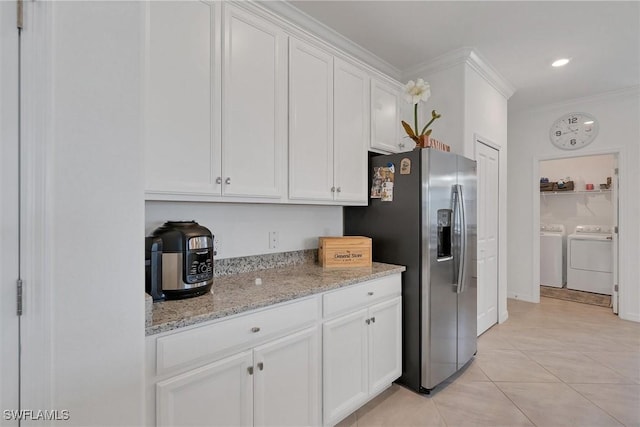 kitchen featuring white cabinets, crown molding, stainless steel fridge, separate washer and dryer, and light tile patterned floors