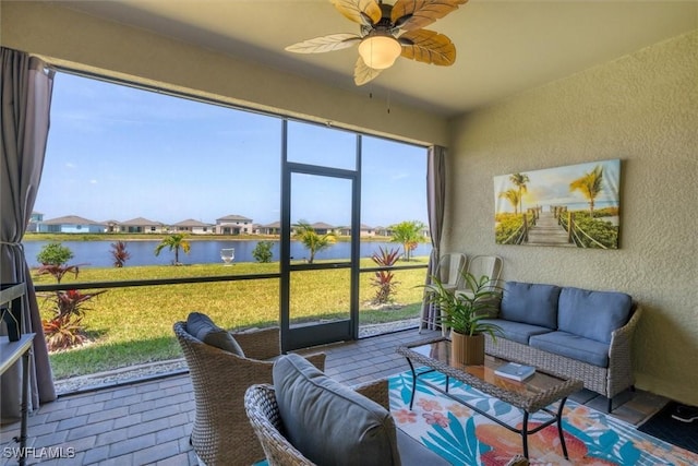 sunroom / solarium featuring a water view and ceiling fan