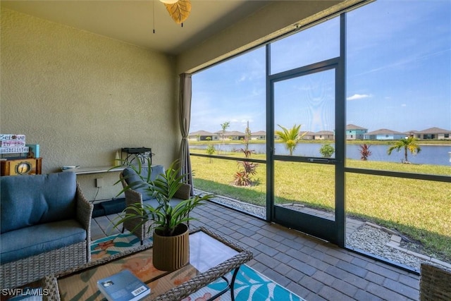 sunroom / solarium featuring a water view and ceiling fan