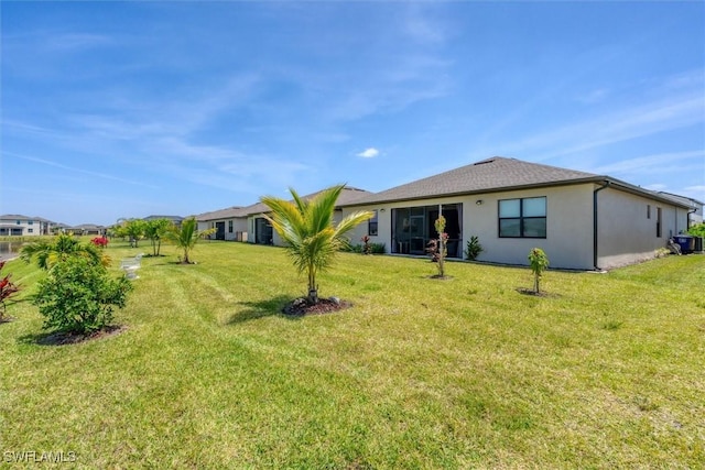 rear view of property featuring a lawn