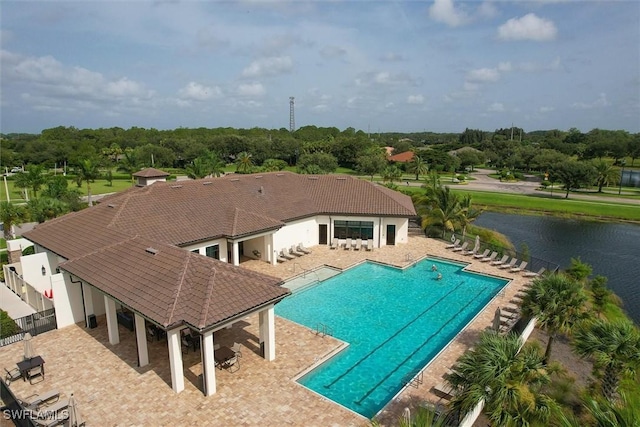 view of pool with a water view and a patio