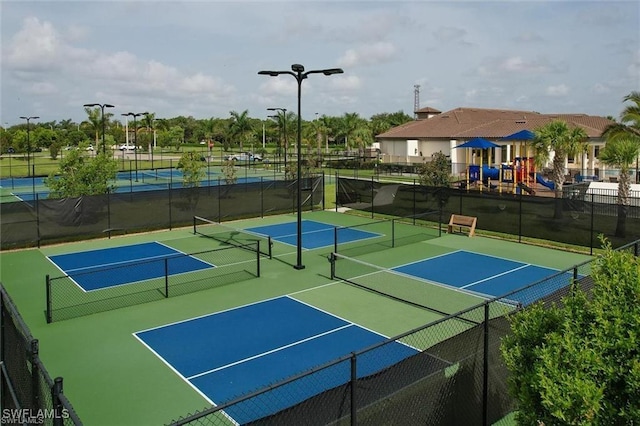 view of tennis court with a playground and basketball court