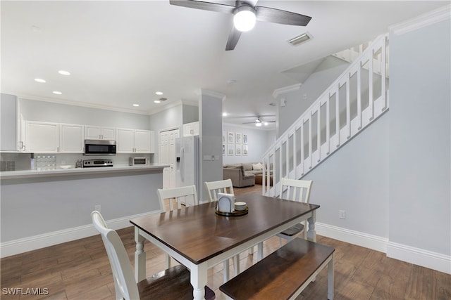 dining room featuring dark hardwood / wood-style flooring, ornamental molding, and ceiling fan