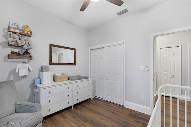 bedroom featuring ceiling fan, dark hardwood / wood-style flooring, and a closet