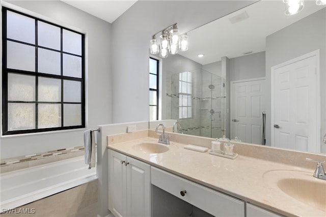 bathroom with vanity and shower with separate bathtub