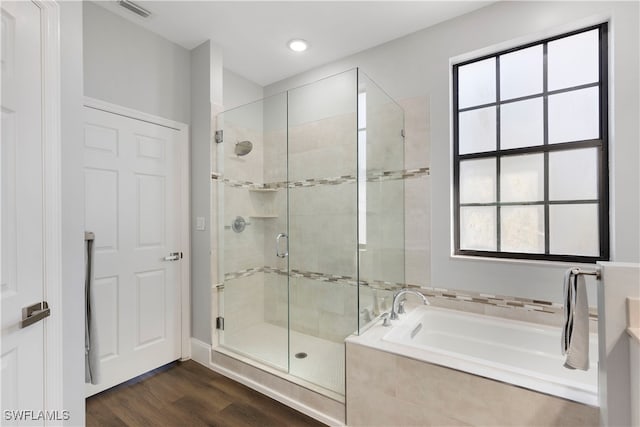 bathroom with hardwood / wood-style flooring and plus walk in shower