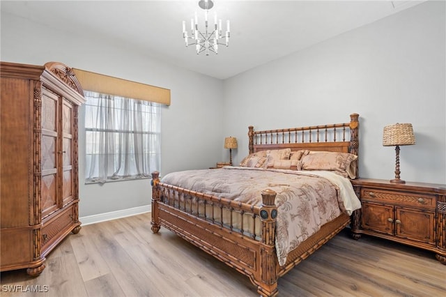 bedroom with a chandelier and light hardwood / wood-style floors