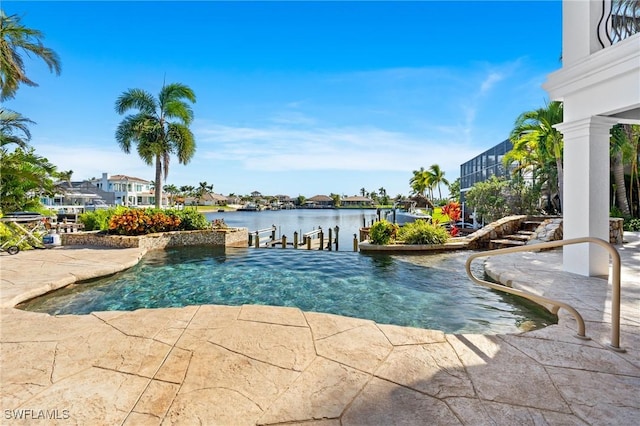 view of swimming pool featuring a water view and a dock