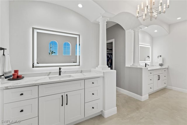 bathroom with vanity, ornate columns, and a notable chandelier