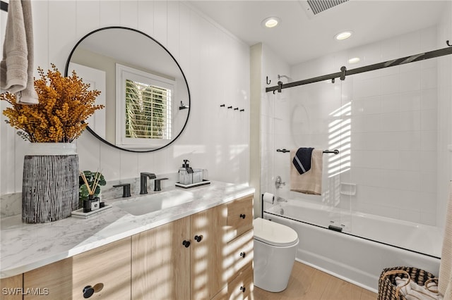 full bathroom with shower / bath combination with glass door, wood-type flooring, vanity, and toilet