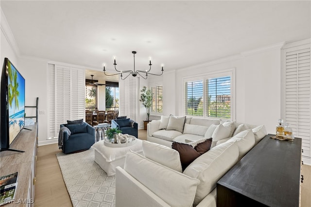 living room with light hardwood / wood-style floors, a notable chandelier, and ornamental molding