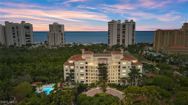 aerial view at dusk featuring a water view