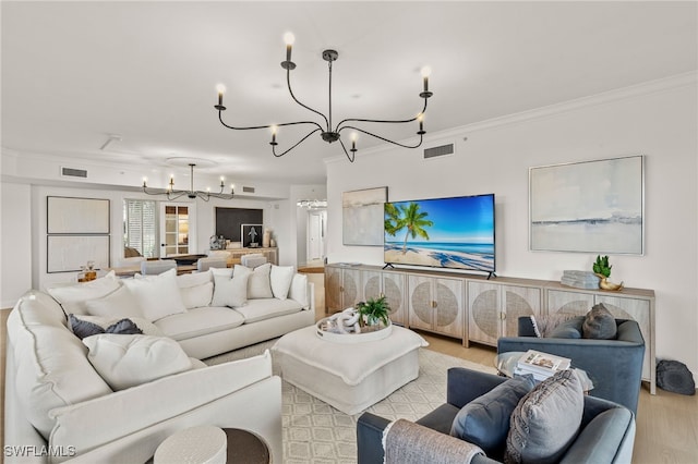 living room featuring light hardwood / wood-style flooring, an inviting chandelier, and crown molding