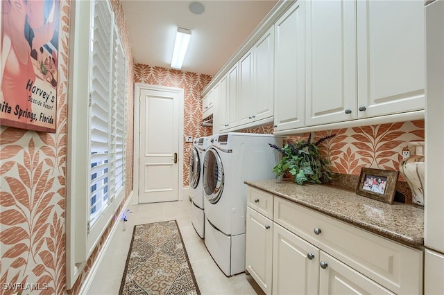 laundry area featuring cabinets, light tile patterned flooring, and washer and dryer