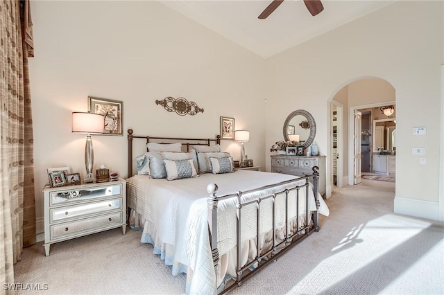 carpeted bedroom with high vaulted ceiling, ceiling fan, and connected bathroom