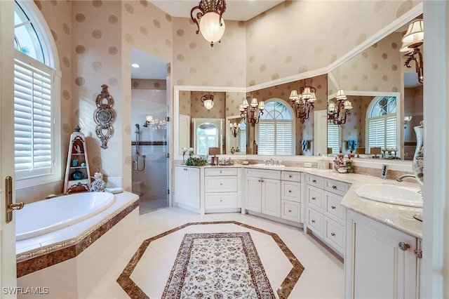 bathroom featuring a chandelier, vanity, and independent shower and bath