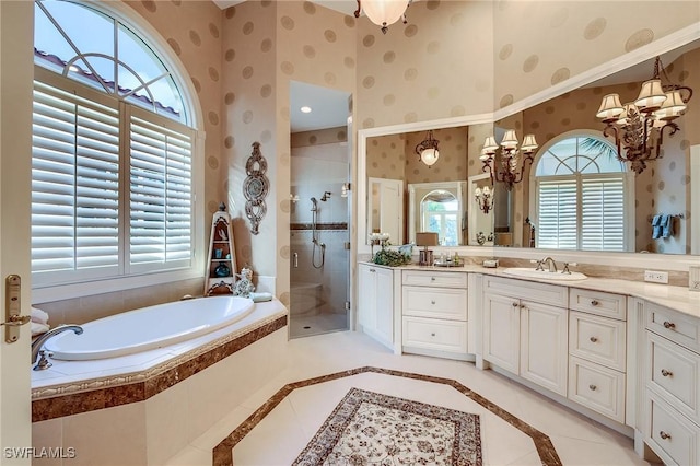 bathroom with a notable chandelier, vanity, and independent shower and bath