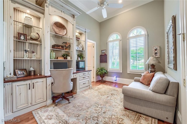 home office with ceiling fan, ornamental molding, and light hardwood / wood-style flooring