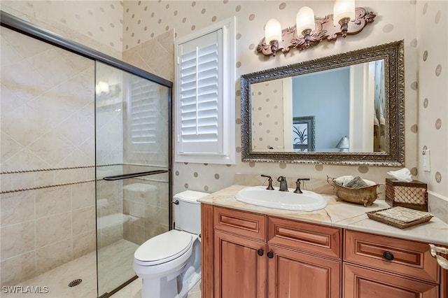 bathroom featuring vanity, toilet, and a shower with door