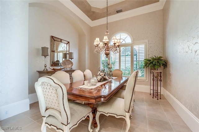 dining room with an inviting chandelier, crown molding, light tile patterned floors, a towering ceiling, and a tray ceiling