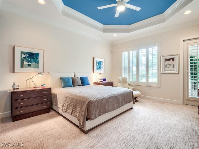 bedroom featuring ceiling fan, light colored carpet, crown molding, and a tray ceiling