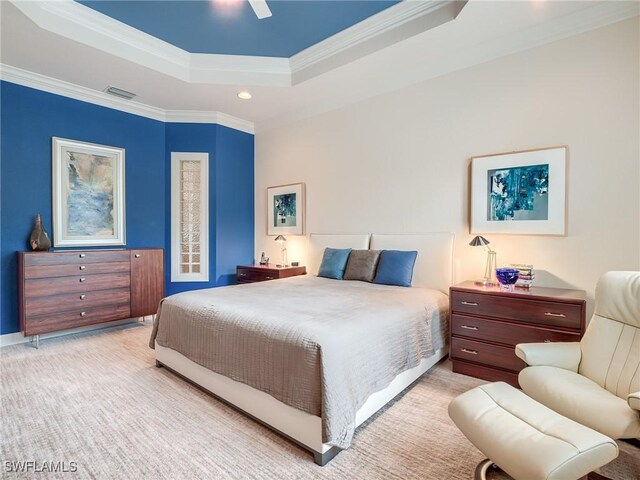 carpeted bedroom featuring ceiling fan, a tray ceiling, and crown molding