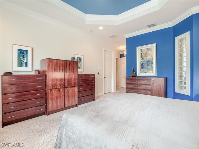 bedroom with ornamental molding, light colored carpet, and a raised ceiling