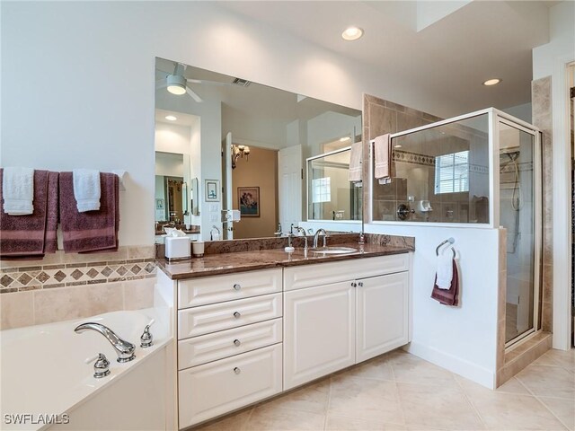 bathroom featuring plus walk in shower, tile patterned flooring, ceiling fan with notable chandelier, and vanity