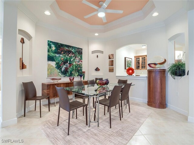 dining room with a raised ceiling, ceiling fan, light tile patterned flooring, and ornamental molding