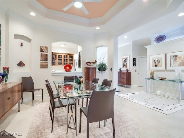 dining area featuring light tile patterned floors, crown molding, and a raised ceiling