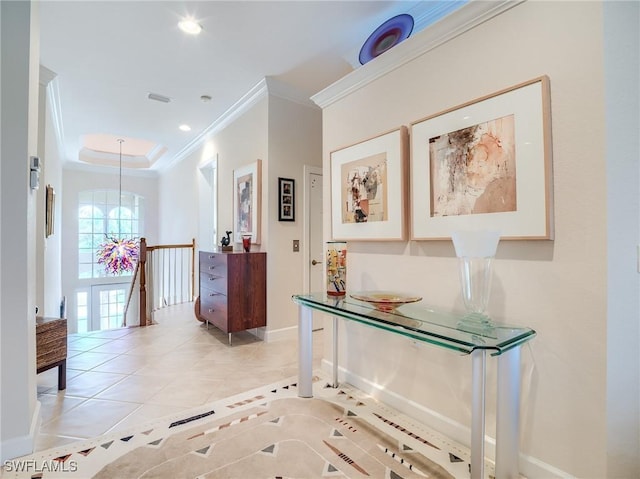 hallway featuring crown molding, light tile patterned floors, a raised ceiling, and a notable chandelier