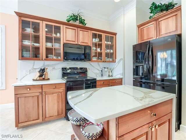 kitchen with backsplash, black appliances, crown molding, light tile patterned floors, and light stone counters