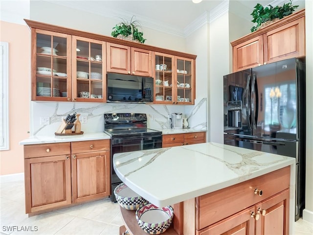 kitchen featuring tasteful backsplash, light tile patterned floors, ornamental molding, light stone countertops, and black appliances