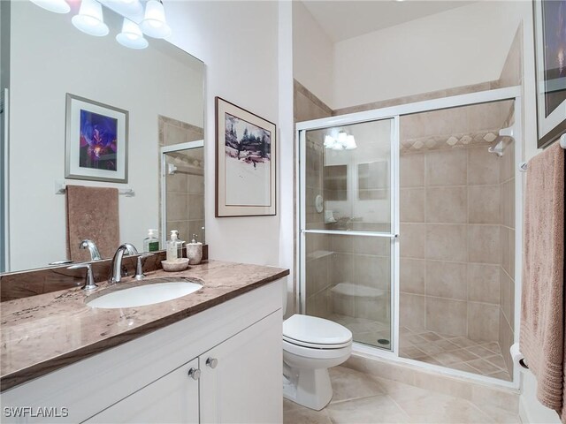 bathroom featuring tile patterned floors, vanity, toilet, and walk in shower