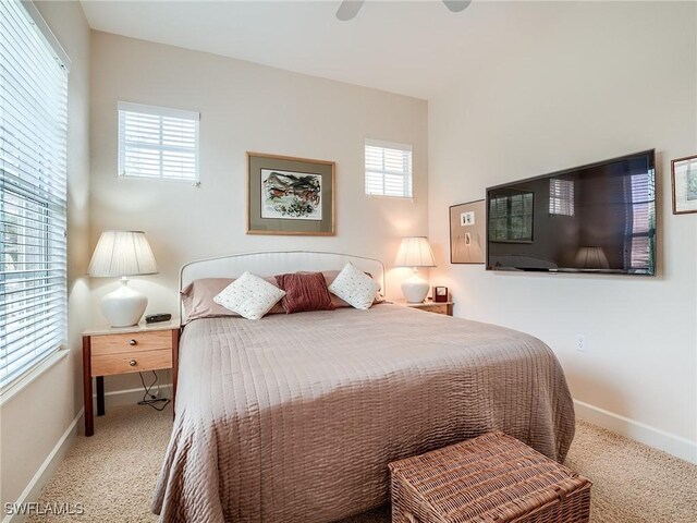 carpeted bedroom featuring ceiling fan and multiple windows