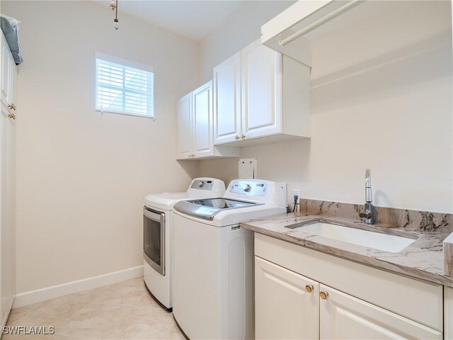 laundry room with washing machine and dryer, cabinets, light tile patterned floors, and sink