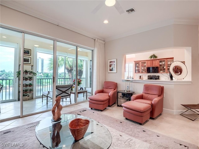 living room with light tile patterned floors, ornamental molding, and ceiling fan