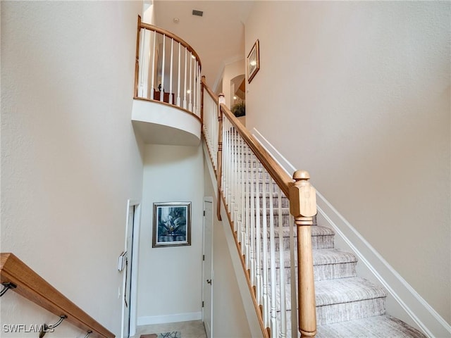 staircase featuring a towering ceiling